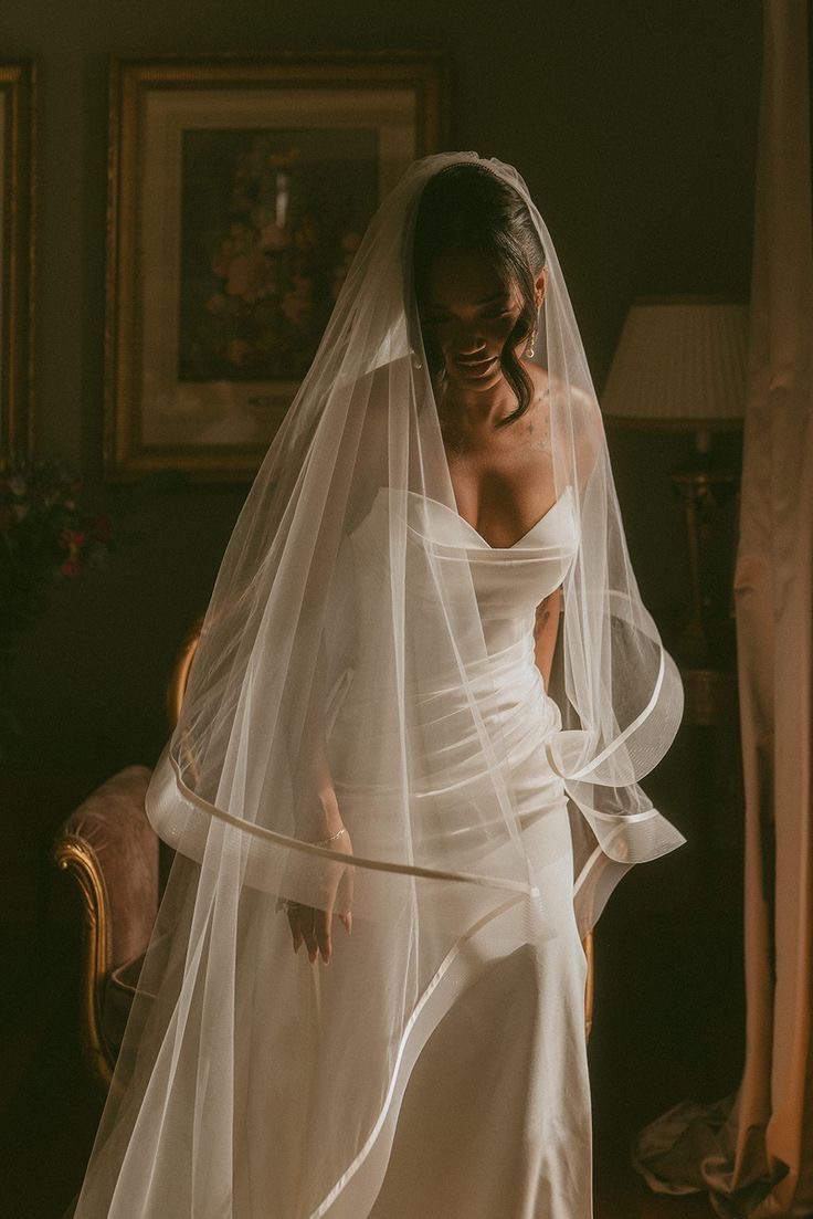 Bride wearing a long veil finished with a sculptural ribbon edge